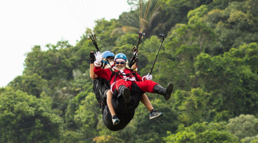 Papai e Mamãe Noel saltam de parapente em programação especial de Natal em São Vicente